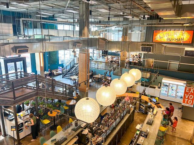 Interior of Durham Food Hall with its bar, seating, and vendor stalls