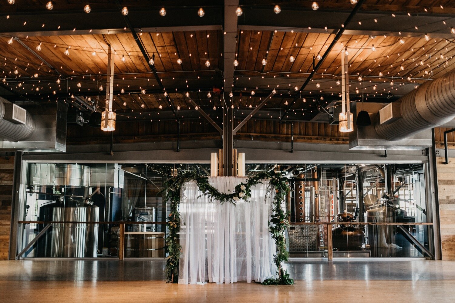 The Rickhouse reception space with string lights, wood ceilings, and wedding decor